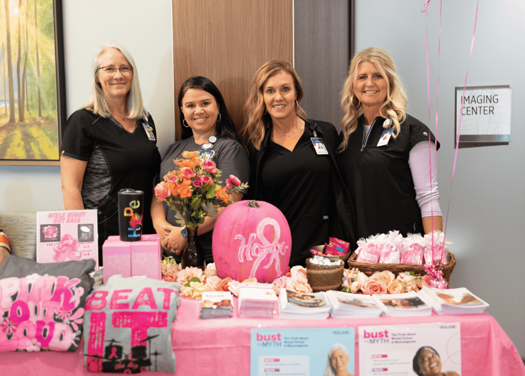A group of health care providers at a breast cancer awareness month event
